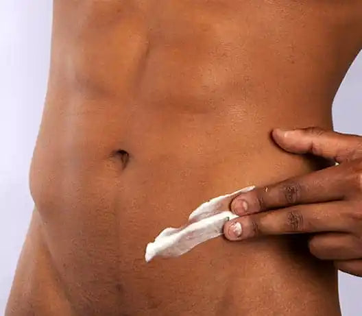 Man applying post-wax bodycare after a male intimate waxing treatment